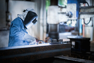 Industrial welder welding fabricated construction in factory, Welding process by Flux Core Welding, FCAW