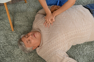 Doctor providing first aid to unconscious senior man