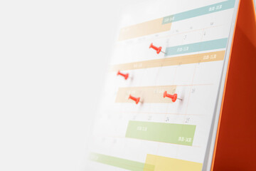 Desk calendar with pins for reminder in office workplace concept of time management agenda event planner or personal organization for business meeting and schedule planning or holiday plan.