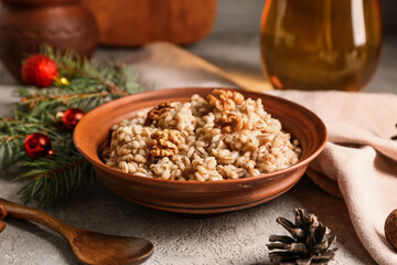 Bowl of traditional Ukrainian Kutya dish with fir branch and Christmas balls on white table