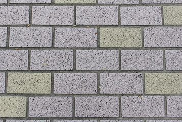 Close up of pink and green square paving tile. Brick pavement texture. Concrete pavers background.