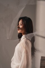 Obraz premium 暖色のトーンで撮影をした若い女性の雰囲気のあるポートレート