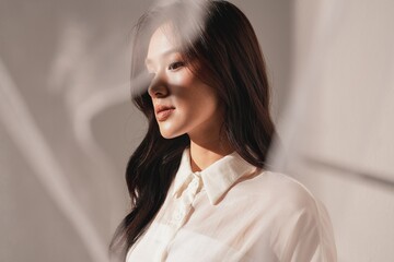 暖色のトーンで撮影をした若い女性の雰囲気のあるポートレート