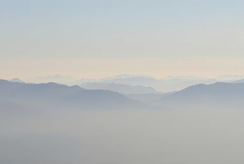 A faint outline of a mountain range in the distance with misty p