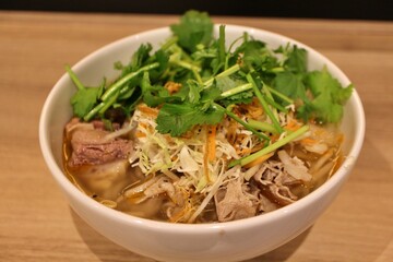 Vietnamese cuisine: bun bo hue (spicy rice noodles with beef tendon and coriander)