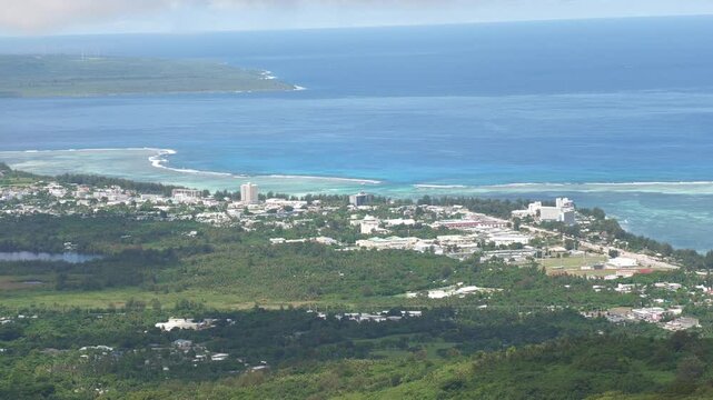 Medium wide footage of Susupe Village and the Saipan lagoon, with Tinian Island in the distance. Saipan, CNMI