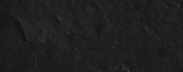 Close-up of a dark slate stone surface showcasing rough, natural texture, perfect for backgrounds or design projects.