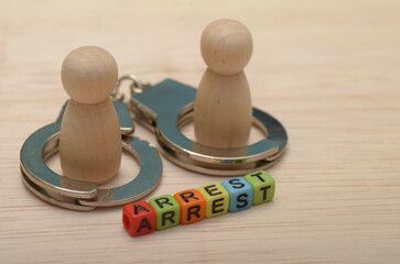 wooden figures with handcuffs and the word 