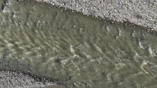 Arda river flowing through a rocky landscape, creating dynamic patterns and textures, in Val Tolla, Lugagnano D'Arda, Piacenza, Italy, overhead close up panning