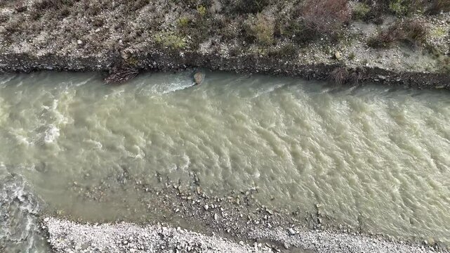 Arda River is flowing through a stony riverbed next to a road and some trees, in Val Tolla, Lugagnano D'Arda, Piacenza, Italy