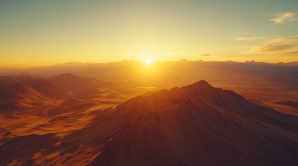 Naklejka premium A breathtaking sunset over a mountain range, casting a golden glow over the landscape.