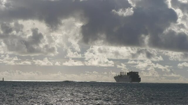 Thick, gray clouds at twilight with a US navy preposition ship anchored at the lagoon