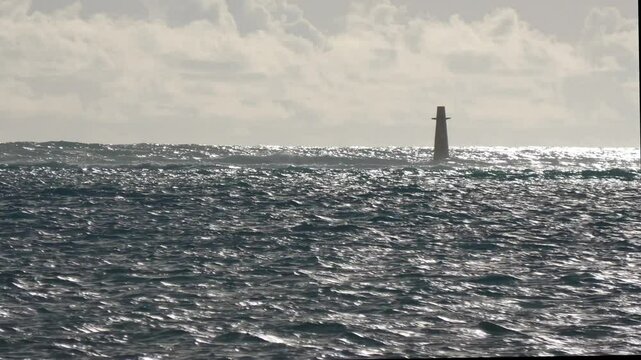 Silhouette of a floating buoy in the sea, twilight shot