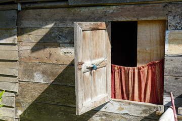 windows of a rustic shack house made from wooden planks and plywood