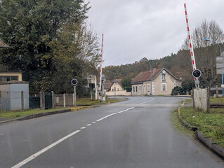 Quiet road intersection with railway crossing in Dordogne France