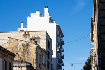 Contrasting architectural styles in a Dordogne street, vibrant sky