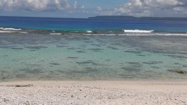 Scenic beach view of Coral Ocean Point, with Tinian island in the distance, Saipan, Northern Mariana Islands.