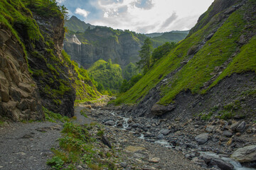 Mountain stream at alpine valley bottom, Hiking trail to Batoni Waterfalls, Switzerland