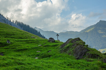 Lonesome holy cross in Swiss Alps, sign of faith in remote high mountains