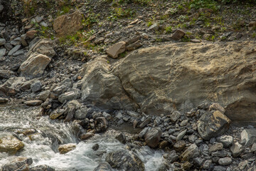 Mountain stream pure water flows on cool rocks close-up, pristine nature background