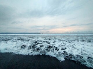 beach atmosphere in the afternoon with big waves and beautiful black sand