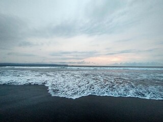 beach atmosphere in the afternoon with big waves and beautiful black sand