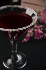 Glass of red cocktail close-up on black background