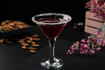 Glass of red cocktail close-up on black background
