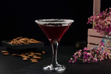 Glass of red cocktail close-up on black background