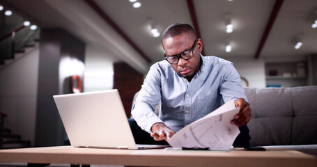 Young African Man Calculating Invoice