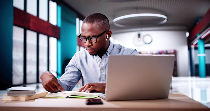 Male Student Studying With Computer Doing Research