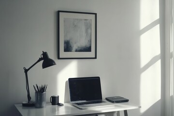Minimalist workspace: laptop, desk lamp, art.