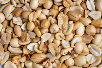 Roasted peanuts (Arachis hypogaea) as background. Peanuts are a popular snack food enjoyed around the world. They can be roasted, salted, or flavored with various spices.