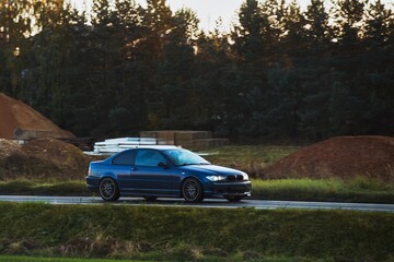 Speeding on a Nature Landscape with a Sporty Vehicle in the Evening Light