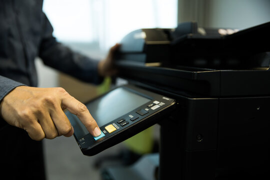 Men use photocopy or copier machine office workplace equipment for make a copy paper or photocopier for scanning document and photocopying service maintenance concepts.