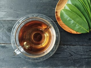 Soursop leaf boiled water in glass on wooden table. Has many health benefits 