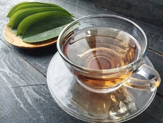Soursop leaf boiled water in glass on wooden table. Has many health benefits 