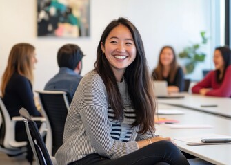 A diverse group of professionals laughing and sharing ideas during an office meeting.