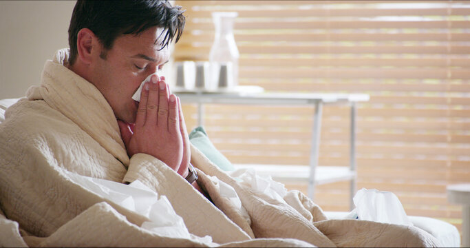 Living room, sinus and man with tissue, home and season for allergies, sick and sneezing with infection. Lounge, winter and symptoms of fever, runny nose and health of person, virus and warm in house