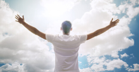 Worship to God. Man in white on sky background. 