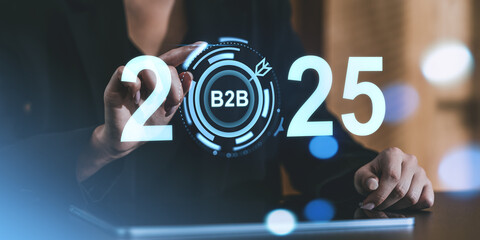 Business professional interacting with digital interface displaying 2025 and B2B concept in a futuristic setting.