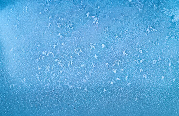 Frost patterns on frozen winter window as a symbol of Christmas wonder. Misted space for your product or lettering. Christmas or New year background.