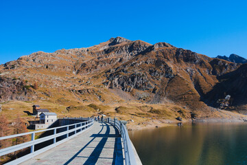Walkway above the hydroelectric dam at lake Laghi Gemelli. In the background the Pizzo Farno and Monte Corte mountains. Orobie Alps, Lombardy, Italy