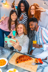 Multi-ethnic friends taking selfie celebrating party eating snacks and drinking