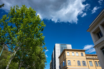 Architettura. Ripresa dal basso di palazzi moderni con cielo azzurro e nuvole bianche.