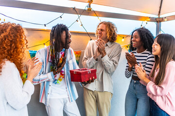 Man thanking friends for the birthday gift at rooftop party