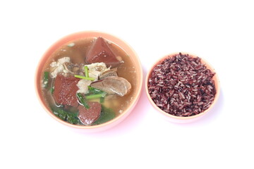Pork blood jelly soup with entrials and riceberry rice (Oryza sativa) in light orange ceramic bowl on white background.