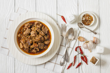 beer braised pork stew in a white bowl