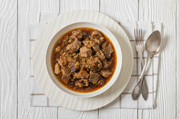 beer braised pork stew in a white bowl