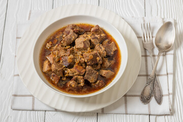 beer braised pork stew in a white bowl